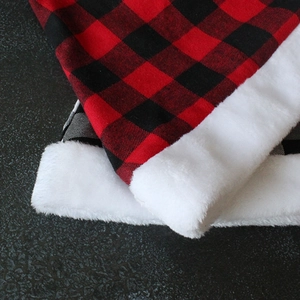 Nahaufnahme der rot-schwarzen Karo-Weihnachtsmütze mit weißem Kunstpelzbesatz