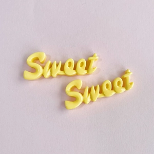 Macro de breloques en résine Sweet jaunes pour barrettes DIY sur fond rose doux