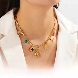 Close-up of gold-plated stainless steel chain with heart, emerald, and love charms