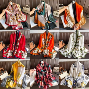 Detailed close-up of multiple silk scarf patterns with floral and geometric designs