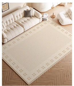 Detail of oatmeal latte geometric chenille rug on wood floor next to beige sofa