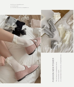 Detail of Lolita style mid-calf socks featuring organza bows and ribbed knit texture