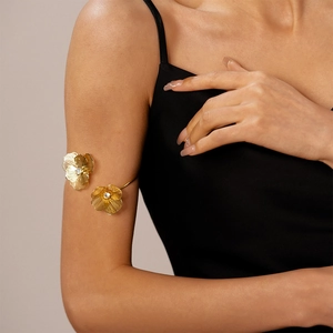 Gros plan du bracelet de bras doré à motif floral et cristaux portés par un mannequin
