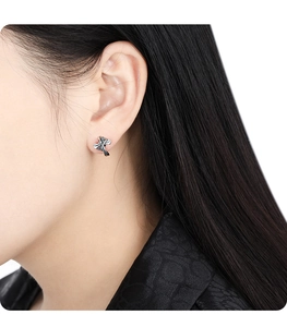 Detailed view of S925 sterling silver cross bow earring with micro-set zircons on ear