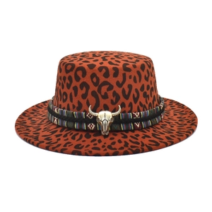 Detail of leopard print fedora hat featuring a metal bull skull buckle and ethnic hat band