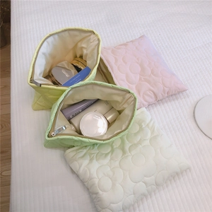 Detailed view of quilted flower pattern on soft down padded makeup storage bags