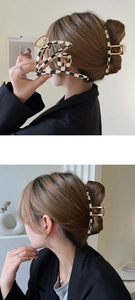 Detail of checkered hair claw clip in black and white with gold accents on hair