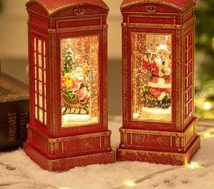 Detail of red vintage Christmas telephone booth lantern with glowing Santa scenes