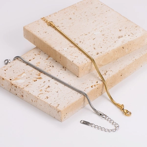 Elegant gold and silver stainless steel snake chain bracelets on beige stone blocks