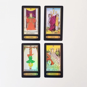 Macro shot of laser-reflective Tarot cards showing Justice and Empress with gold borders