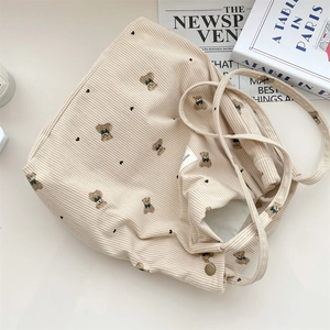 Detailed close-up of corduroy tote bag featuring cartoon bear and heart prints