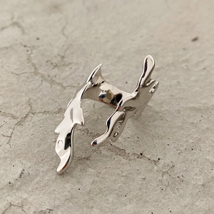 Detailed macro view of abstract flame-shaped silver ring with polished liquid metal texture