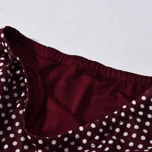 Detail of burgundy polka dot mesh fabric with elastic waistband and fine stitching