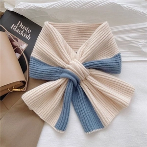 Detail of blue and beige ribbed knit scarf showing texture and cross-over design