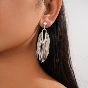 Detailed close-up of silver tassel earrings with geometric frame and fine bead chains