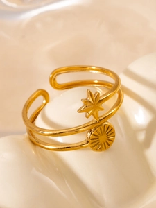 Macro detail of gold-plated double-layered ring with star and sunburst motifs