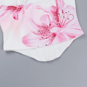 Detailed view of pink floral print on white tank top with curved hem and precision stitching