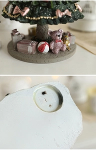 Detail of Christmas tree resin base with tiny gift boxes and the battery compartment