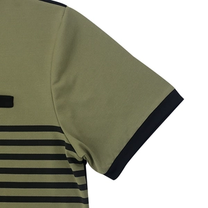 Détail du polo en maille vert olive avec rayures noires et col contrasté de haute qualité