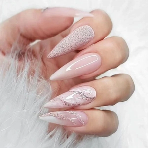 Close-up of long stiletto press-on nails with pink marble, glitter, and nude designs