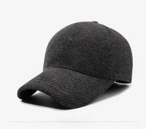 Detail of dark grey knit baseball cap featuring twill texture and silver metal side logo