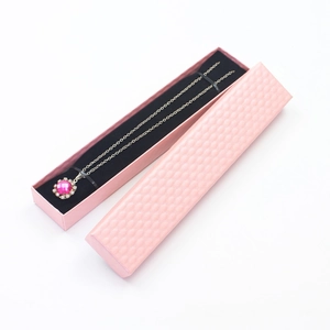 Detailed view of a pink textured jewelry gift box with a pink gemstone necklace inside