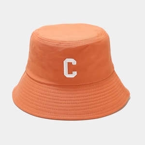 Détail d'un chapeau bob orange avec broderie lettre C blanche et coutures renforcées