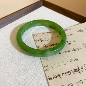 Macro shot of a minimalist green resin bangle with marble texture on vintage background