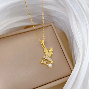 Détail d'un pendentif colibri doré avec strass brillants, perle et pierre de zircon