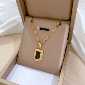 Minimalist titanium steel gold necklace with a black rectangular pendant in a jewelry box
