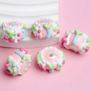 Close-up of colorful resin beads with cream and fruit motifs for DIY jewelry making