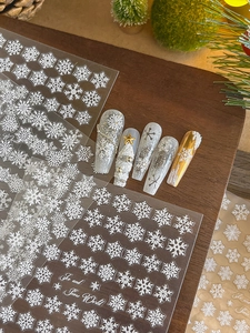 Detailed 3D relief Christmas snowflake nail stickers with festive winter art on wooden surface