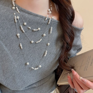 Close-up of elegant layered pearl necklace on model with sparkling bead accents