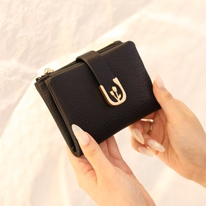 Detail of black pebbled PU leather wallet with gold tulip clasp and zipper closure