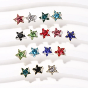 Star-shaped rhinestone nail art charms in colorful alloy settings on a wavy white background
