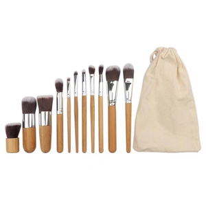 Professional 11-piece bamboo makeup brush set with canvas bag on white background