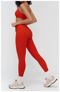 Close-up of red high-waist yoga set showing elastic brushed fabric and lifting effect