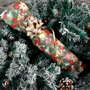 Large Christmas gift wrapping paper roll with festive prints and a golden sequin bow