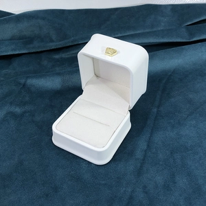 Close-up of a white PU leather jewelry box with a gold crown and double ring slots