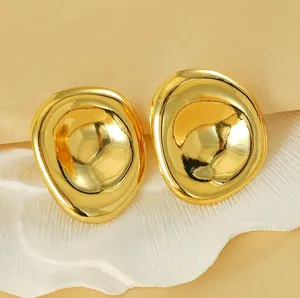 Macro shot of 18K gold irregular concave earrings on silk, showing liquid metal texture