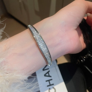 Vue macro d'un bracelet ouvert argenté avec des rangées de zircons cubiques scintillants