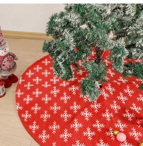 Detail of red Christmas tree skirt with white snowflake jacquard pattern and plush knit texture