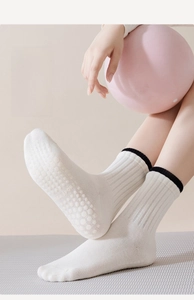 Detail of white cotton yoga socks featuring 100+ non-slip silicone beads on the sole