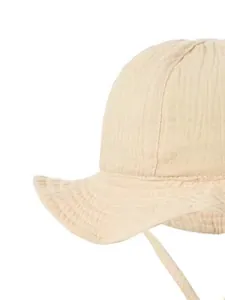 Detail of baby cotton sun hat with wave brim and chin straps in cream textured fabric