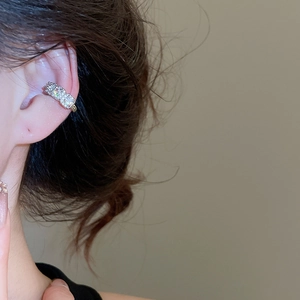 Detail view of silver ear cuff with triple-row pavé zircon crystals on model ear