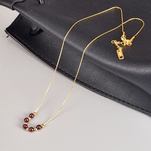 Dettaglio della chiusura placcata oro 18K con incisione K18 su collana di granato
