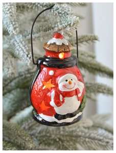Lanterne bonhomme de neige rouge et blanche avec étoiles sur un sapin de Noël