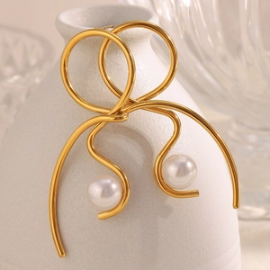 Knot design 18K gold plated stainless steel pearl earrings on white ceramic vase