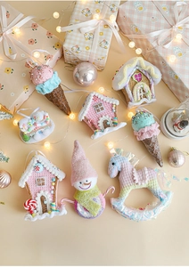 Detail of pink Christmas ornaments with gingerbread house and snowman in soft lighting