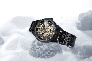 Close-up of FORSINING black mechanical watch on ice, showing golden skeleton gears